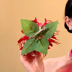 Back view detail of a tropical red fabric flower hair clip with metal duckbill clip.