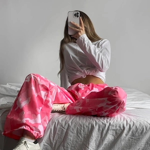 Dettaglio dei pantaloni cargo camouflage rosa con orlo a coulisse e vestibilità relax