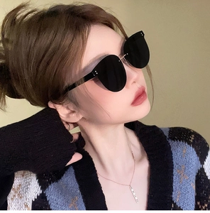 Detail view of oversized rimless black sunglasses with silver dot accents on side frame