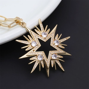 Detailed view of an 8-point gold star pendant with sparkling cubic zirconia on a gold chain