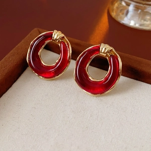 Detail of vintage red resin round earrings with polished gold outer frames