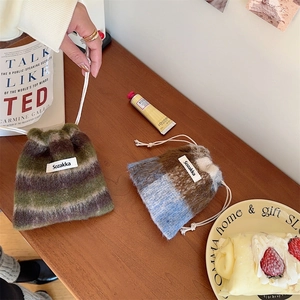 Close-up of wool knit drawstring pouch with striped pattern and soft plush texture