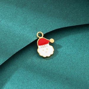 Detail of Santa Claus charm with red and white enamel on green textured background