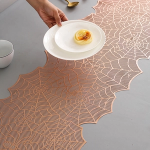 Detailed view of rose gold laser-cut spider web table runner for festive dining decor