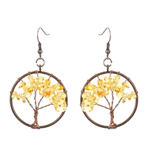 Detail of handmade wire-wrapped tree of life earrings with yellow crystal stones