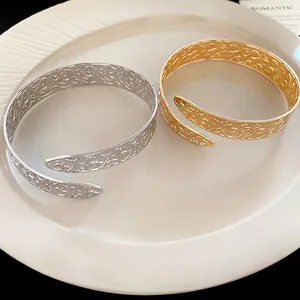 Vintage style hollowed-out metal arm cuffs in gold and silver with vine patterns