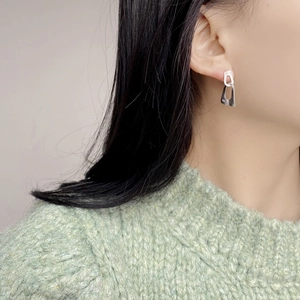 Macro shot of S925 sterling silver brushed earring detail on a female model