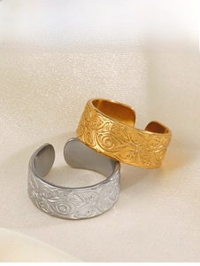 Macro view of vintage relief pattern texture on gold and silver stainless steel rings