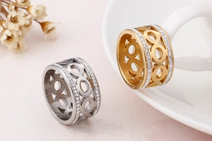 Detailed view of hollow circular rings in gold and silver with double row zircon inlays