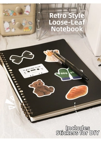 Detail of matte black DIY ring binder with vintage bronze coils and cute stickers