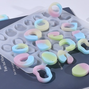 Macro de bagues en résine géométriques et moule en silicone translucide sur fond bleu