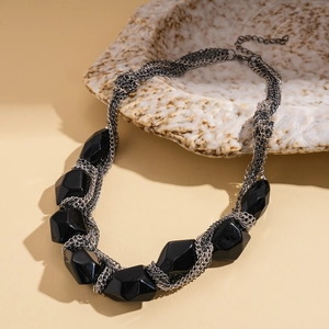 Détail d'un collier multicouche de style sombre avec des perles acryliques facettées