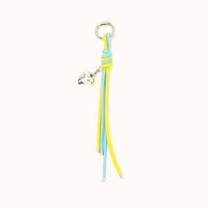 Handmade blue and yellow braided leather keychain with silver heart pendant on white background