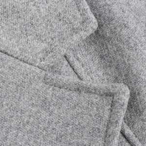 Macro shot of gray wool fabric texture and high-quality stitching on a long coat