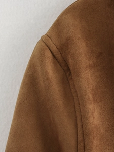 Gros plan sur les coutures d'épaule et la texture d'une veste en daim marron