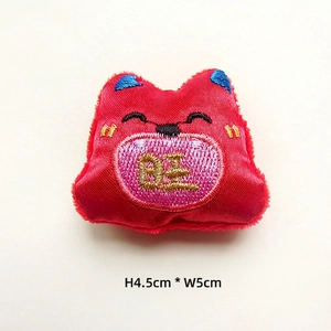 Detail of red stuffed lucky cat ornament with golden Wang embroidery, 4.5cm x 5cm