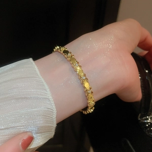Macro detail of 18k gold plated iris flower bracelet with sparkling white zircons