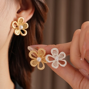 Gros plan détaillé de boucles d'oreilles fleurs évidées avec perles dorées et argentées