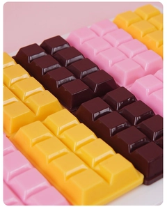 Macro view of realistic PVC chocolate charms in pink, brown, and yellow colors