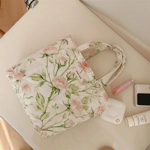 Close-up of quilted floral tote bag with pink rose patterns and 'simple wish' label