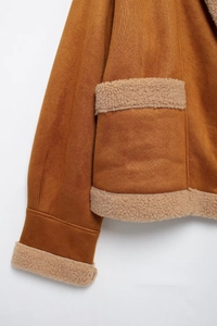 Detail der braunen Wildlederimitat-Jacke mit weichem beigem Teddyfutter an den Ärmeln