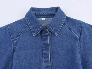Detailansicht eines dunkelblauen Jeanshemdkragens mit S-Etikett und Knopfverschluss