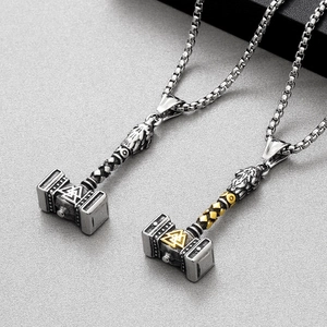 Detail of Viking Thor Hammer Mjolnir pendants in silver and gold-tone steel finishes