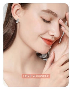 Close-up of S925 sterling silver moissanite hoop earring on model with LOVE YOURSELF text