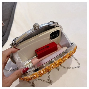 Top view of pumpkin evening bag interior showing capacity for smartphone and lipsticks