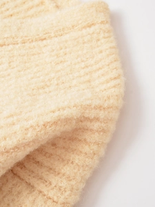 Détail d'un cardigan crème montrant la texture en maille côtelée et la matière pelucheuse