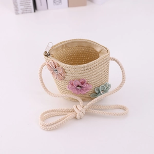 Detail of a beige woven straw crossbody bag for girls with colorful floral embroidery