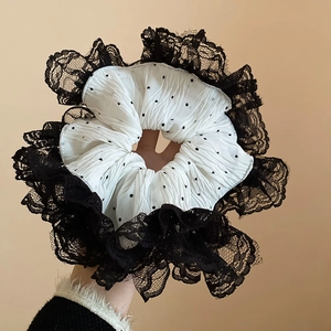 Gros plan sur chouchou à pois noir et blanc avec des bords élégants en dentelle