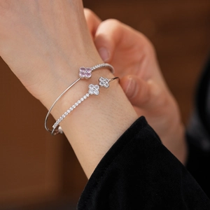 Detailed view of silver double-layered bangle with pink zircon flowers on a model's wrist