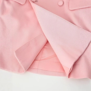 Detailed view of pink blazer hem showing textured fabric and high-quality lining