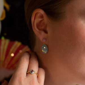 Detail of vintage star and moon enamel earrings and ring set in gold with blue stones