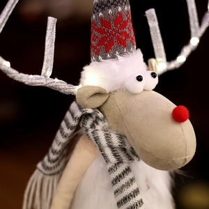 Close-up of plush Christmas reindeer with glowing LED antlers and snowflake knit hat