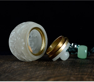 Macro detail of sandalwood lotus pendant with white jade texture and brass threaded cap