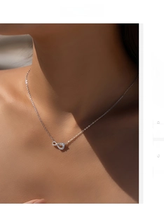 Close-up of s925 silver infinity pendant necklace with white zircons on model neck