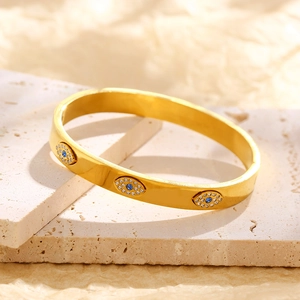 Vintage stainless steel gold bangle featuring evil eye charms with blue zircon stones