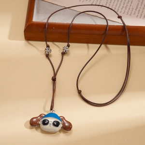 Detail of cartoon puppy pendant with blue hat and sunglasses on brown leather cord necklace