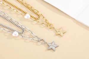 Detail of double-layer gold and silver necklaces with star charm and heart pearl pendant
