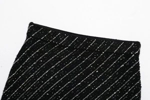 Detailed macro view of the black knit fabric with white stripes on the skirt waistband