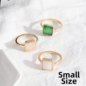 Detailed top view of small gold alloy ring set with square green pink and white stones