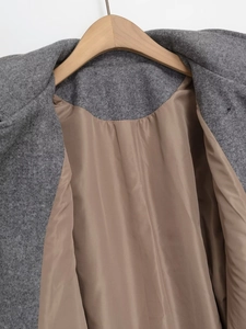 Close-up of grey wool coat showing lapel detail and silky champagne lining texture