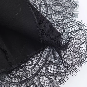 Detailed macro view of black lace fabric with eyelash edges and fine stitching detail