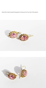 Detail shot of vintage gold earrings with pink oval gemstones and filigree borders