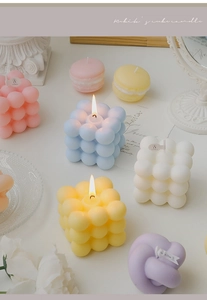 Artistic layout of Rubik's cube and knot candles in pastel colors with decorative props