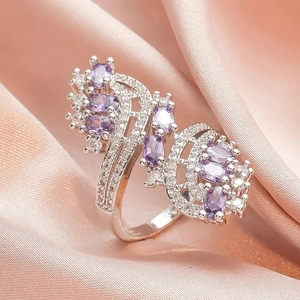 Detailed close-up of silver ring with oval purple stones and sparkling zircon stones