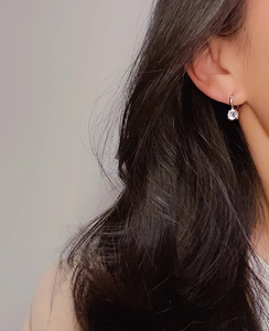 Close-up of a silver titanium steel hoop earring with a sparkling round zircon stone