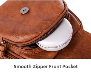 Detail of smooth metal zipper and spacious front pocket on brown textured leather bag